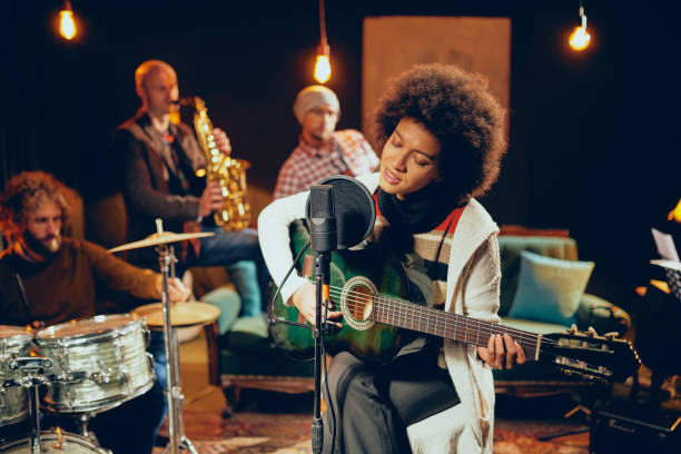 istock Mixed race woman singing and playing guitar. 1098030286