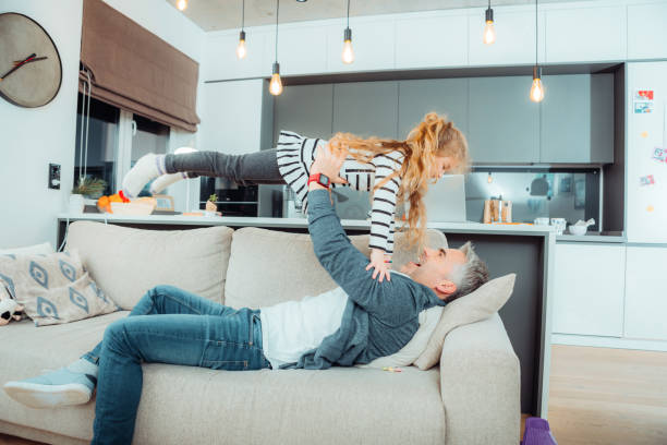 istock Handsome grey-haired father playing with his small daughter 1098031680