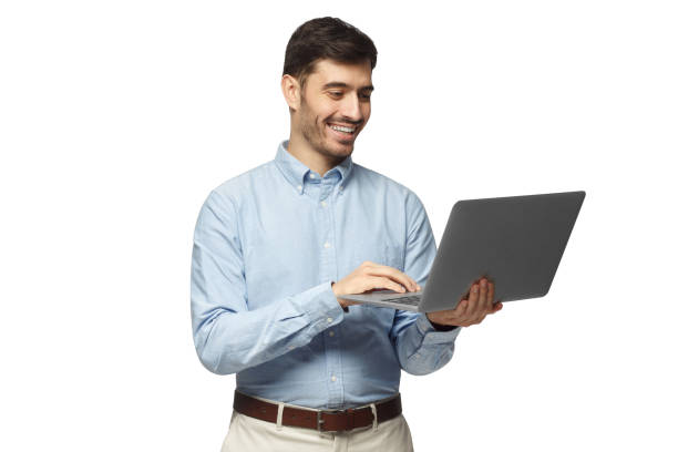 istock Young businessman using laptop, laughing, standing and smiling, isolated on white background 1098036034