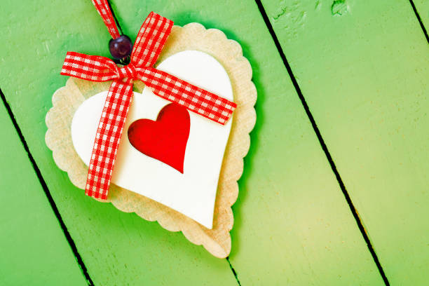 Ornate handmade heart on a green painted wooden background. Space for copy.