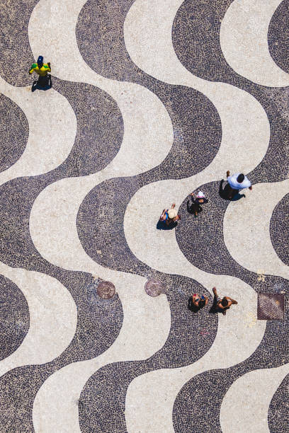 rio de janeiro, brazil, top view of people walking on iconic copacabana sidewalk - rio de janeiro copacabana beach ipanema beach brazil imagens e fotografias de stock