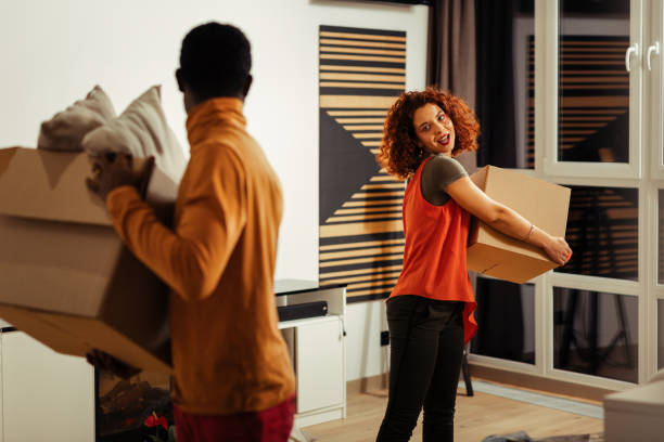 istock Curly wife joining her husband while caring boxes with cushions 1098045442