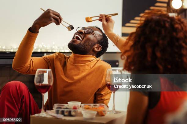 Couple Having Fun While Eating Sushi At Home After Fast Delivery Stock Photo - Download Image Now
