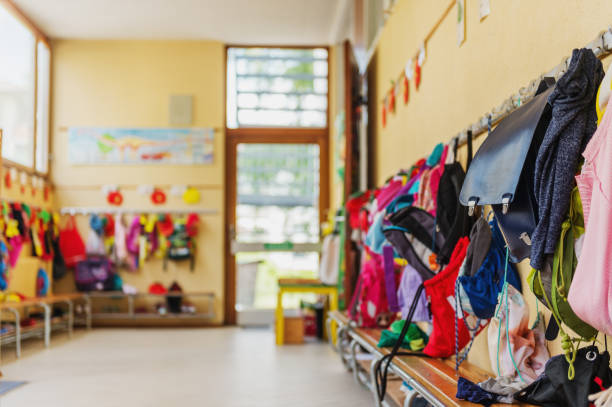 Empty hallway in the school, backpacks and bags on hooks, bright recreation room stock photo