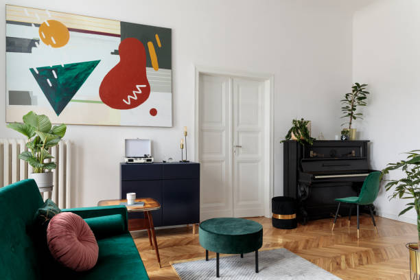 istock Luxury home interior with design velvet sofa, armchair, tables, pouf, commode and accessroies. A lot of plants on the piano. White walls with painting. Sunny view. Stylish decor of sitting room. 1098074876