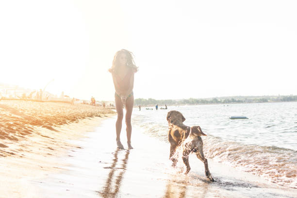 istock Woman Running With Dog in the beach 1098084320