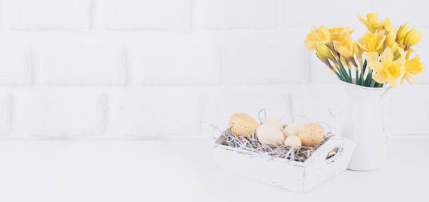 istock Jar with narcissuses and eggs at the white brick background. Spring and Easter concept 1098107212