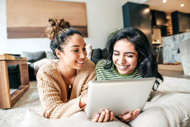 istock Two female students with digital tablet and cellphone at home 1098111970