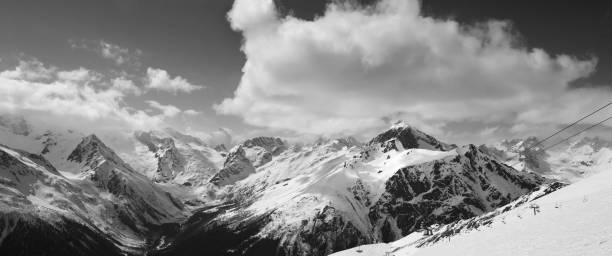 istock Black and white panorama of ski slope and cloudy mountains 1098113636