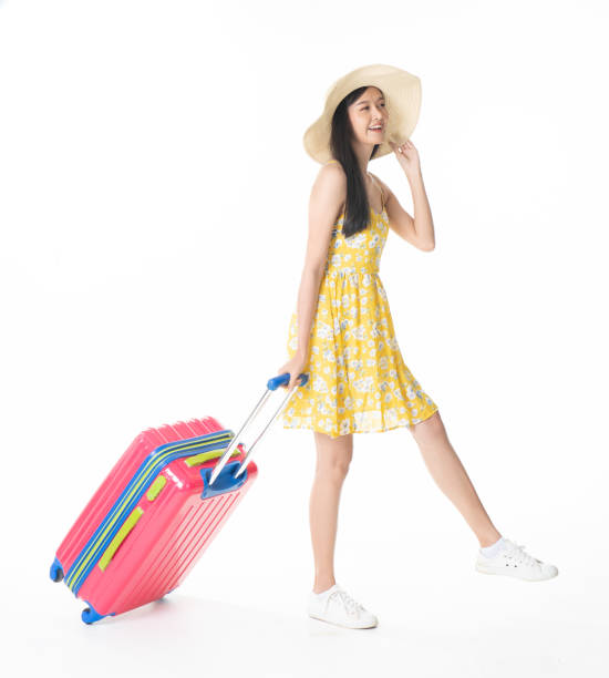 istock Beautiful young woman smiling and pulling pink color luggage isolated on white background.Asian woman going to summer vacation.Travel trip funny. 1098144152