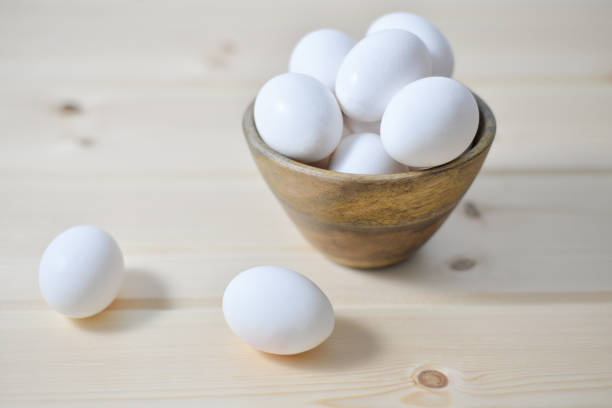 white eggs on wooden plate stock photo