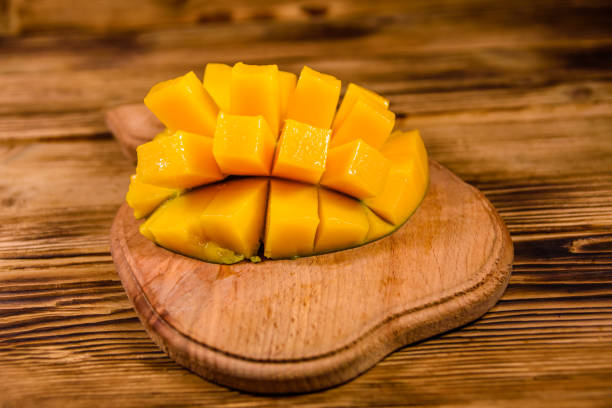 istock Cutting board with chopped mango fruit on a wooden table 1098163508