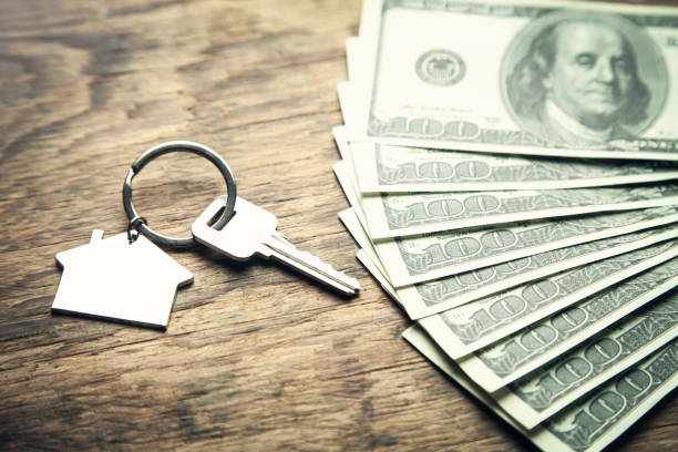 istock House key and dollars on a wood background. 1098192300