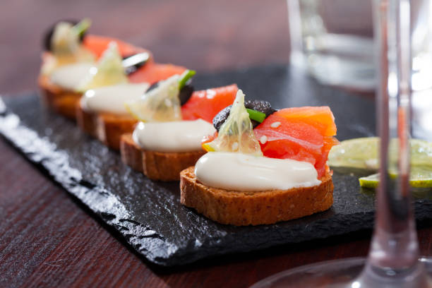 istock Sandwiches with salmon, olives and white sauce on a chopper board 1098192514