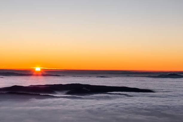 istock Beautiful sunset over a valley filled by fog with mountains and hills 1098198708