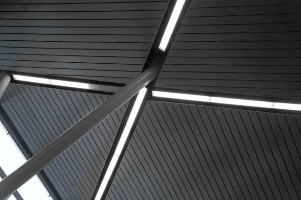 istock Computer graphic image of industrial premises interior fragment with sloped supporting pillar, modular drop ceiling and X-shaped daylight lamps. Abstract modern architecture. 1098202954