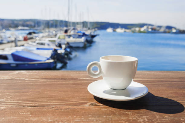 istock Cup of coffee outdoors with sea at background 1098205198