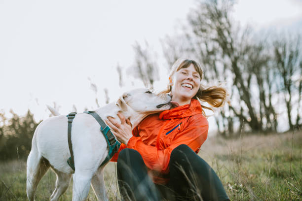 woman embracing pet dog outdoors - coat warm clothing one person joy imagens e fotografias de stock