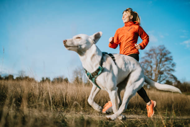 Woman Running Outdoors With Pet Dog