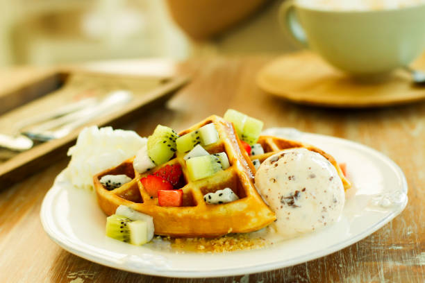 istock Waffle snacks, fresh fruit and ice cream in a white plate on a wooden table 1098206050