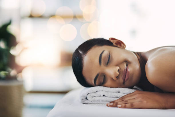 I'm moving in starting from today Shot of a relaxed an cheerful young woman getting a massage indoors at a spa spa lady stock pictures, royalty-free photos & images