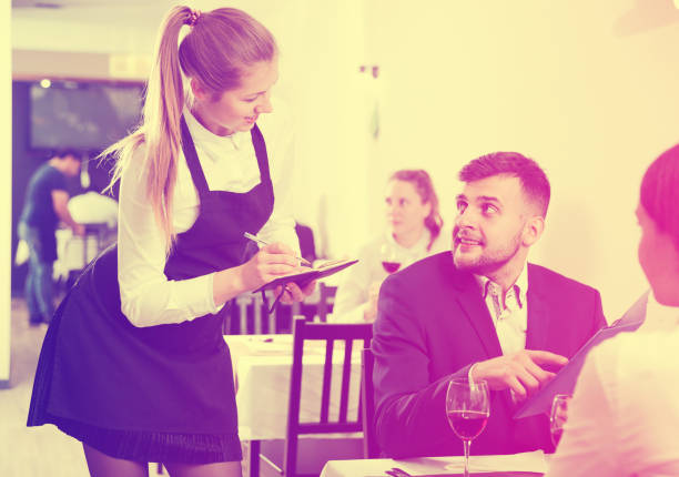 istock Woman waiter is taking order from clients in restaurante 1098211782