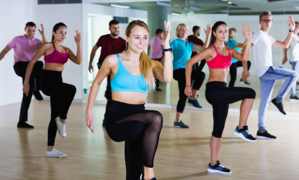 People training at dance class Glad people of different ages studying zumba dance elements in dancing hall curtseying stock pictures, royalty-free photos & images