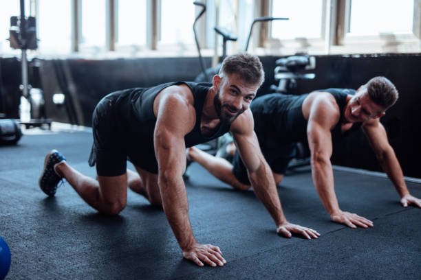 istock Two man doing push ups in the gym 1098211990