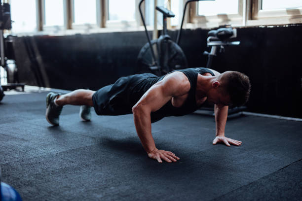 istock Man doing push ups in the gym 1098212116