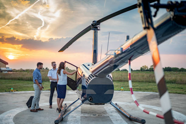 istock Businesspeople by the helicopter with pilot before the flight 1098212454