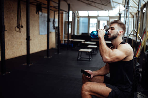 istock Tired man drinking water in a gym 1098214378
