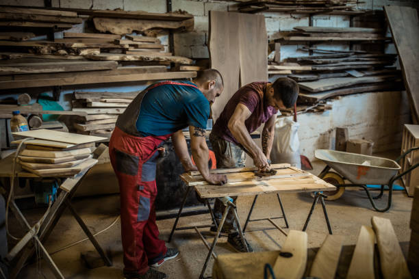 istock Two carpenters making furniture while working together in a workshop. 1098214656