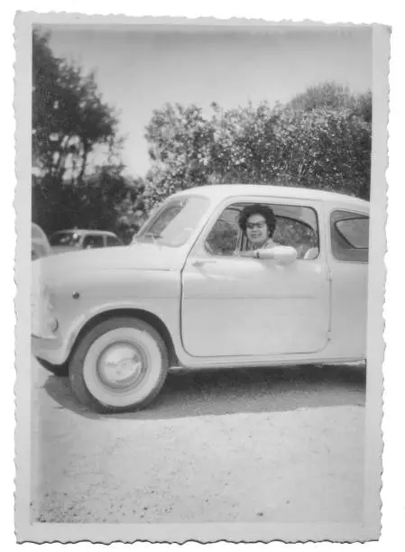 Young woman driving FIAT 600 car in 1960