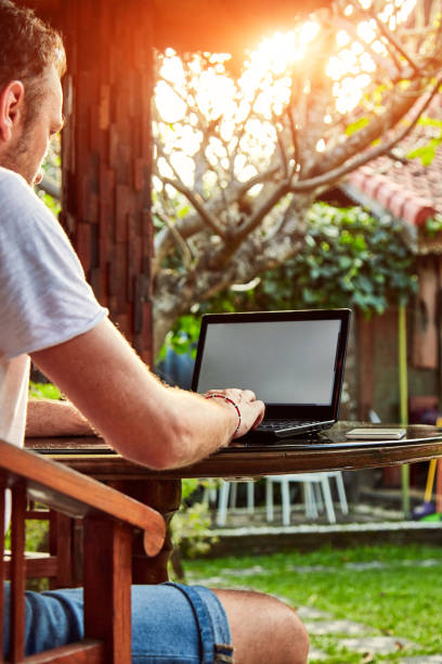 istock Man with coffee / tea and laptop on a home porch. 1098226376
