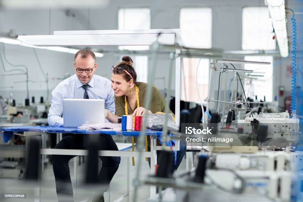 Adult man and woman in factory Bank manager and small business owner working with computer. Business Stock Photo