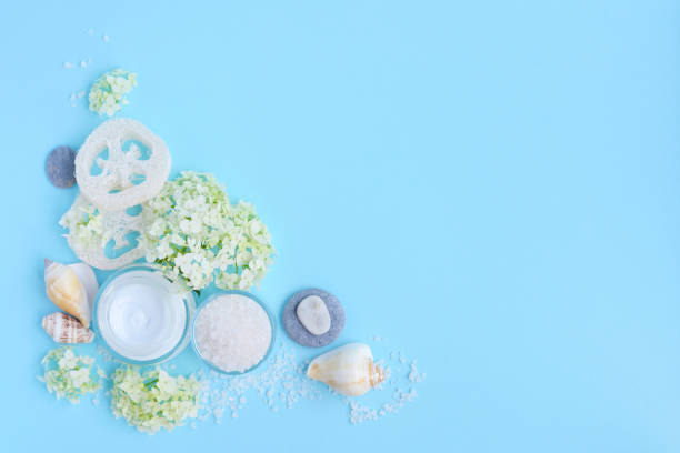 istock Spa composition with cream, salt, shells and flowers on a blue background with empty space for text. 1098231550