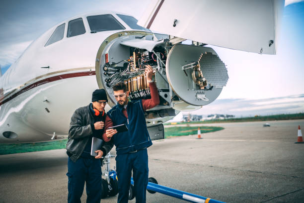 istock Two aircraft engineers working on a sensor array under the nose cone of a private jet parked on an airport tarmac 1098231620