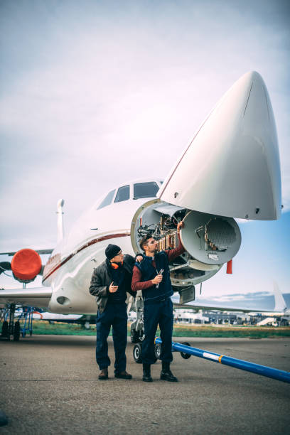 istock Two aircraft engineers working on a sensor array under the nose cone of a private jet parked on an airport tarmac 1098231994