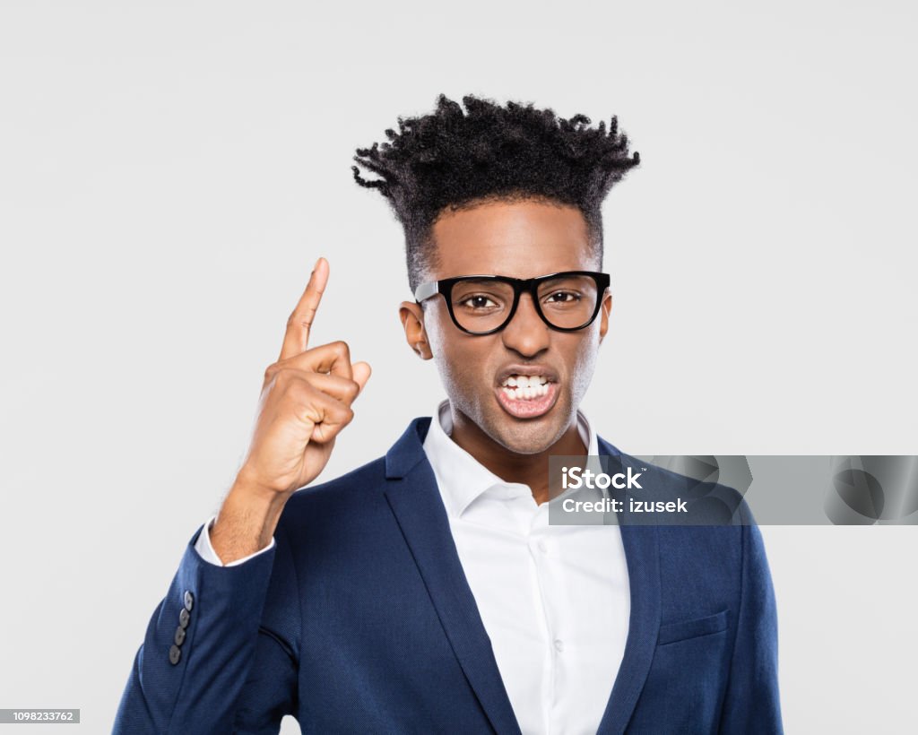 Portrait of angry afro american business man Portrait of angry afro american business man on gray background Adult Stock Photo