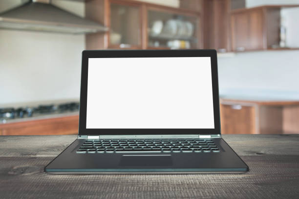 istock Laptop with empty blank screen on wooden tabletop with modern blur kitchen background. 1098235198