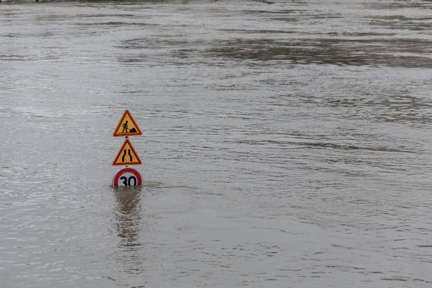 inundaciones de agua. señales de tráfico cubiertas de agua - river road sign road sign fotografías e imágenes de stock