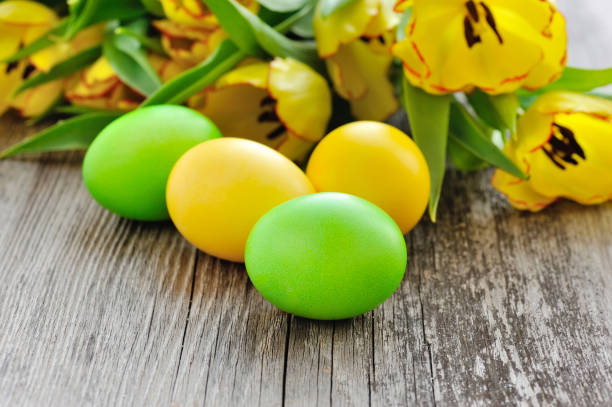 istock Easter eggs with tulips on old wooden table 1098240374