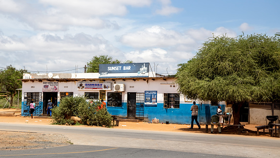 Nata, Botswana, 7 January -2019: Roadside bar selling alcohol with acacia trees providing shade for customers