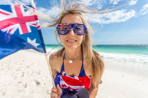 istock Female on beach waving the Australian flag cheerfully 1098241712
