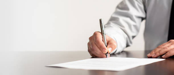 Signing Official Document Businessman Signing An Official Document will legal document photos stock pictures, royalty-free photos & images