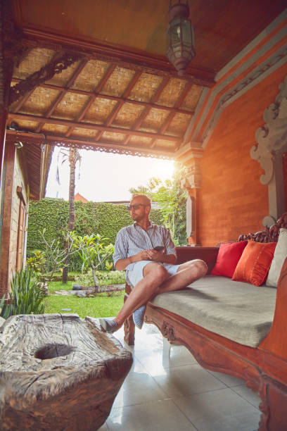 istock Man using smart phone on a terrace sofa in summertime. 1098244284