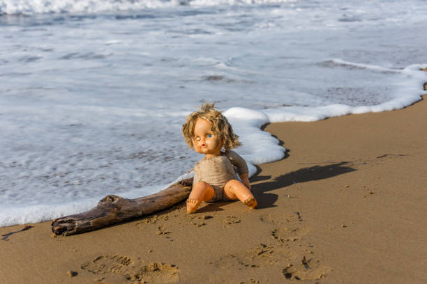 istock Cast Away Broken Doll Washed up on a Beach 1098246636
