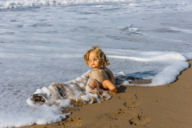 istock Cast Away Broken Doll Washed up on a Beach 1098246828