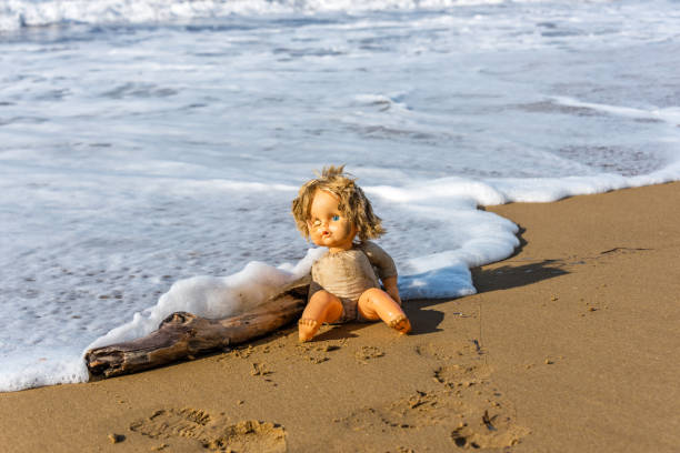 istock Cast Away Broken Doll Washed up on a Beach 1098246998