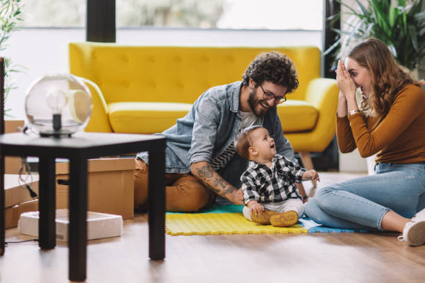 istock Cheerful parents playing with son at new home 1098247366
